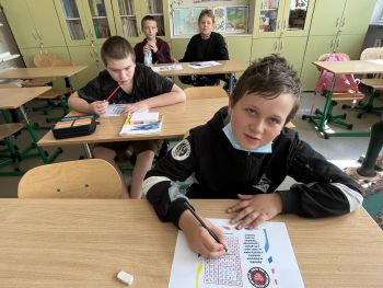 chłopcy piszą na kartce
