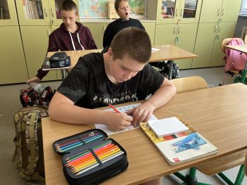 chłopcy piszą na kartce