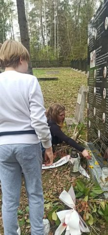 Składanie żonkili przy płycie pamiątkowej