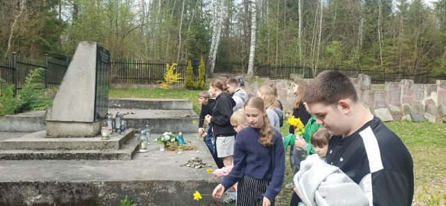 Uczniowie składają żonkile przy pomniku